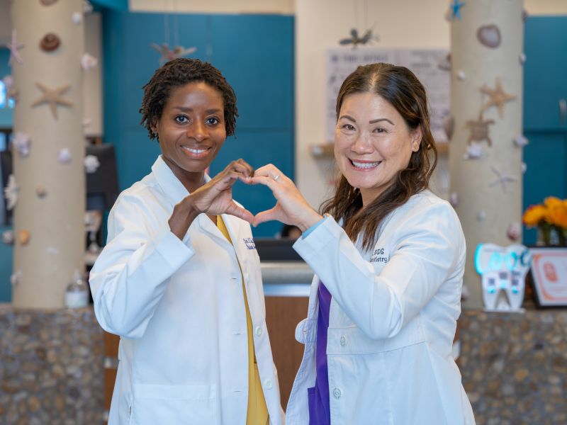 Dr. Linh Tsai and Dr. Judy Brown making a heart together
